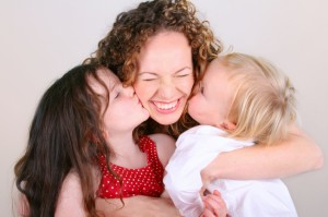 children kissing mother iStock